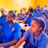 KCT students in blue uniforms seated together in a classroom, ready to enroll and learn